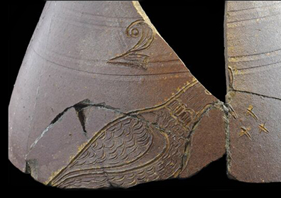 Brown bodied salt glaze stoneware pitcher with incised bird with small x-shaped marks in front the of the bird’s beak, resembling insects. Vessel also marked with an incised and stylized “2”  for a two gallon capacity mark.  The decoration on this vessel has been attributed to the workshop of Chester Webster (1799 -1882). Webster came to Fayetteville, North Carolina to make pottery around 1830. By 1840, he was in Randolph County and working for potters Solomon and B. Y. Craven. This vessel is believed to date to the 1840s or 1850s, based on the color and decorative style (Hatch et al. 2017: 84).  